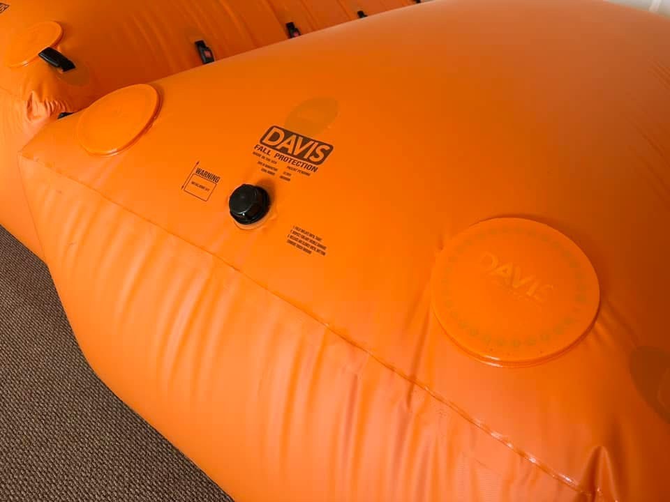 Close-up of a Davis fall protection bag with its inflation cap and circular orange pressure relief covers above the seam